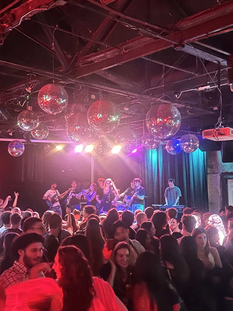 A packed crowd under disco balls watching the band